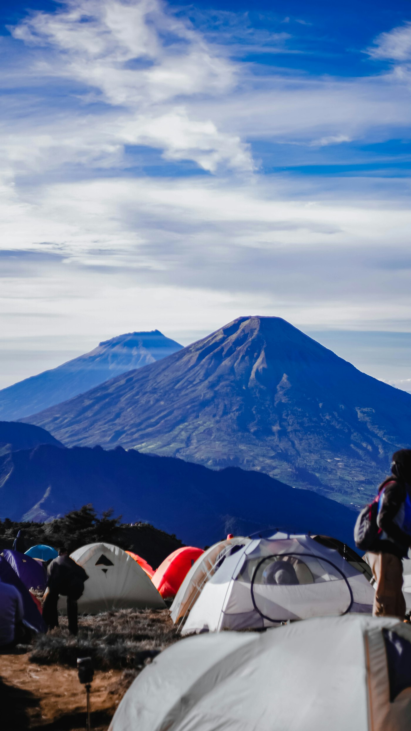 Tents at a mountain campsite beneath a blue sky